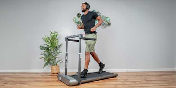A man running on the treadmill at home.